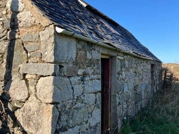 The old stone building on the farm, weathered granite walls and a slate roof