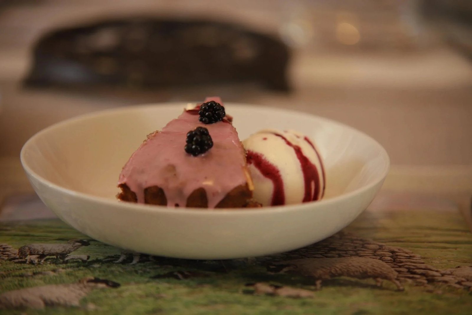 A bowl of Highland Fold ice cream with blackberries and a berry sauce